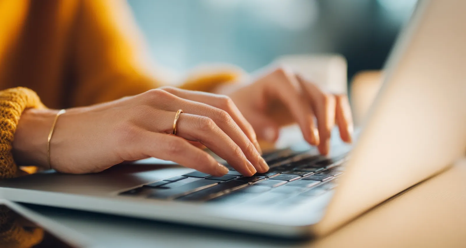Person's hands typing on a computer keyboard.
